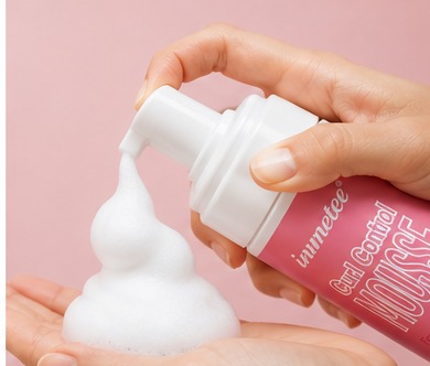 Foam dispensed into a palm before applying to curls